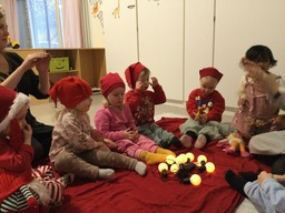 Lapset esittelevät lelupäivän lelujaan piirissä istumalla.