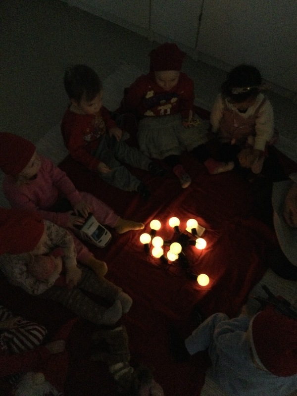 Lapset istuvat hämärässä valojen ympärillä.