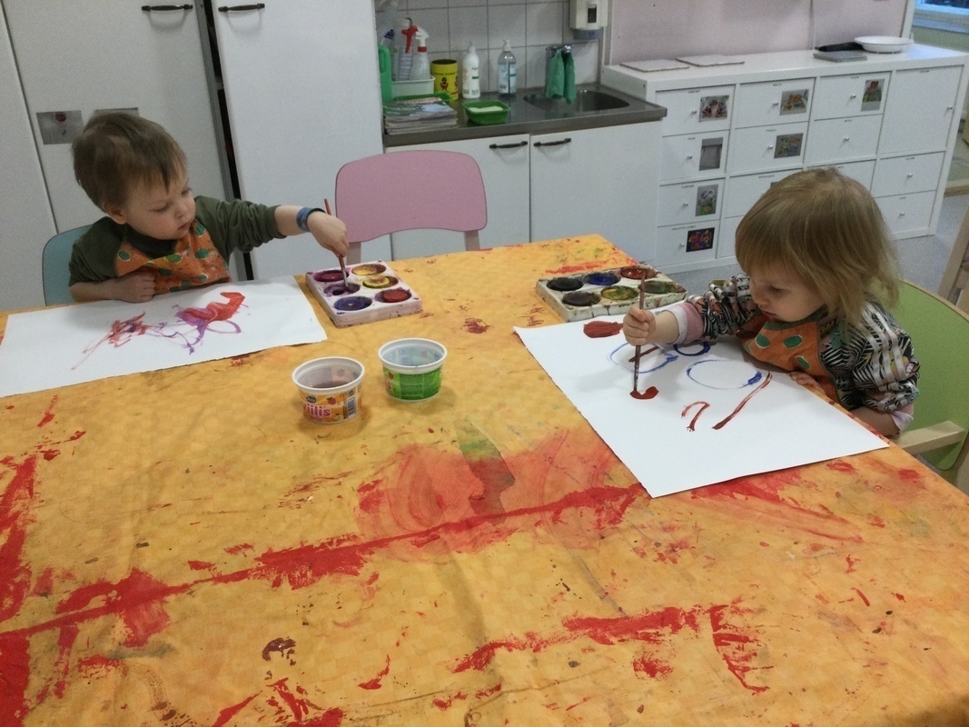 Lapset maalaavat ison pöydän ääressä.
