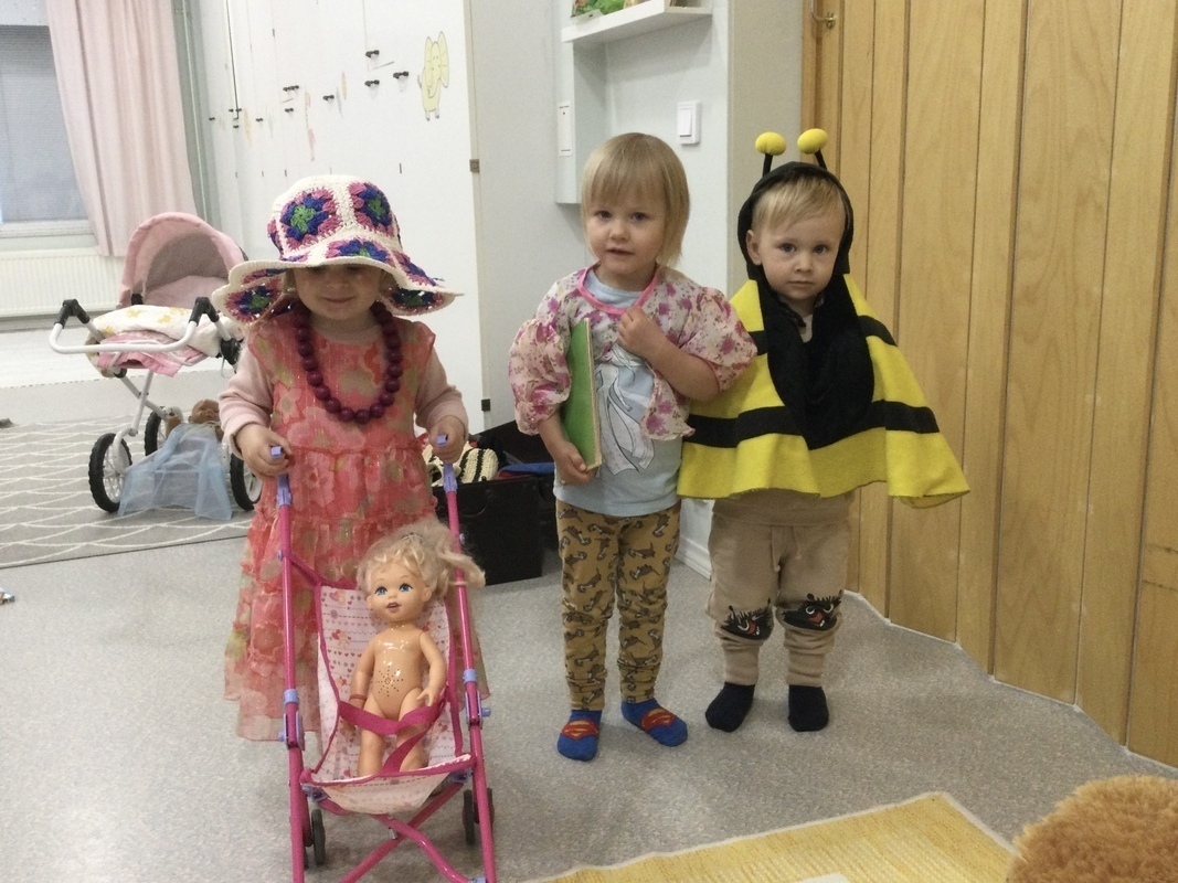 Lapset leikkivät sisällä roolileikkivaatteilla.