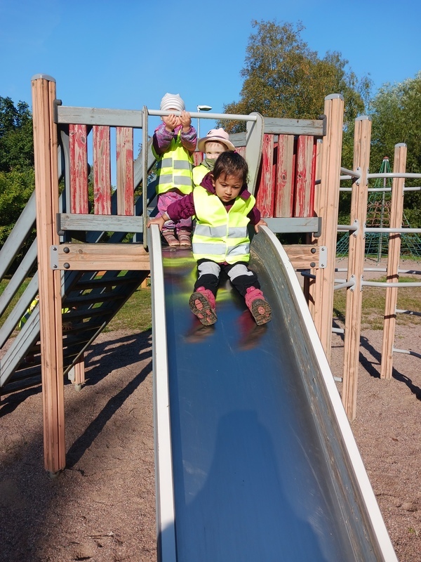 Lapset liukuvat liukumäessä.