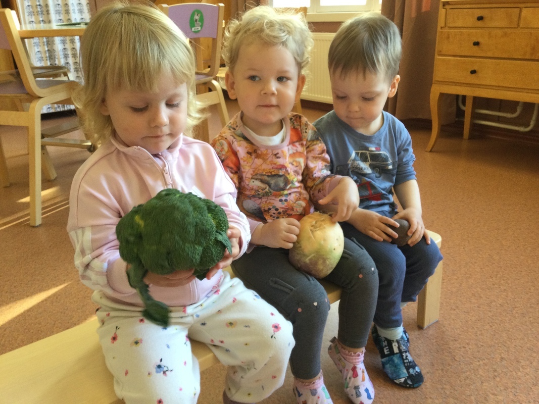 Lapset pitävät valitsemiaan kasviksia käsissään.