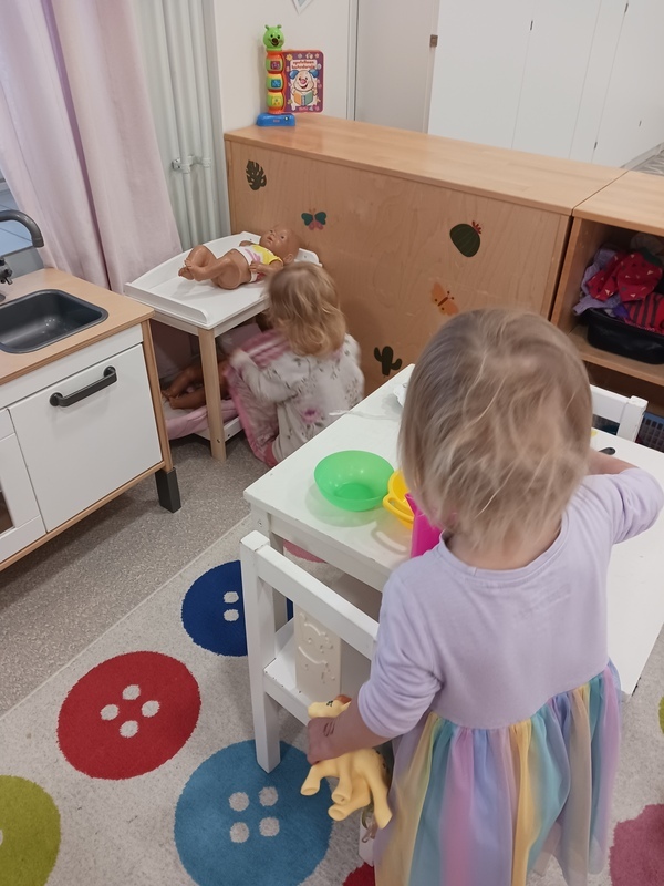 Lapset tekevät leikkiruokaa ja hoitavat nukkeja.