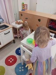 Lapset tekevät leikkiruokaa ja hoitavat nukkeja.