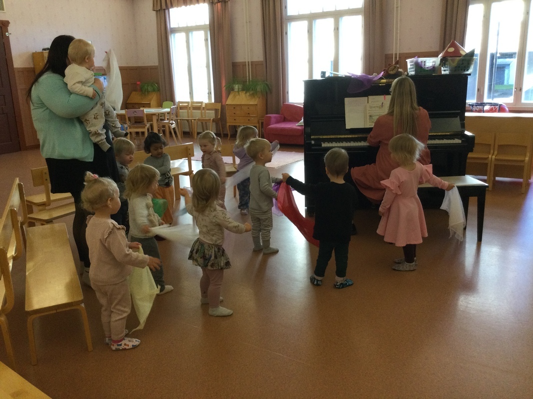 Lapset ovat salissa musiikkituokiolla laulamassa syyslauluja.