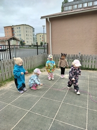 Lapset hyppäävät kiemurtelevan narun yli.