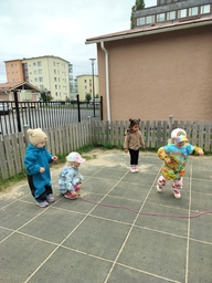 Lapset hyppäävät kiemurtelevan narun yli.