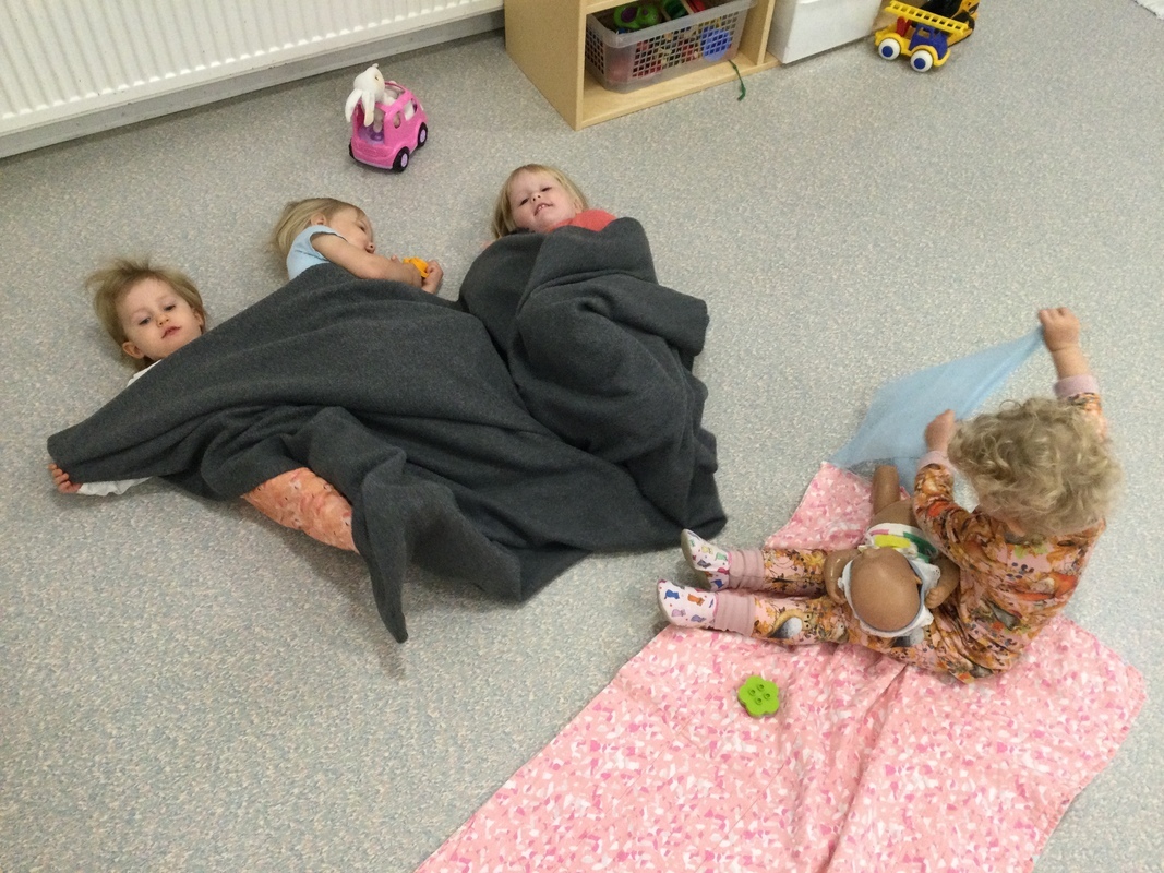 Lapset leikkivät retkeilyä ja ovat peiton alla.