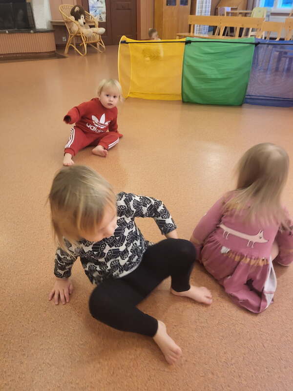 Lapset leikkivät jumppasalissa.
