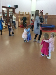 Lapset ja aikuiset tanssivat valssia salissa.