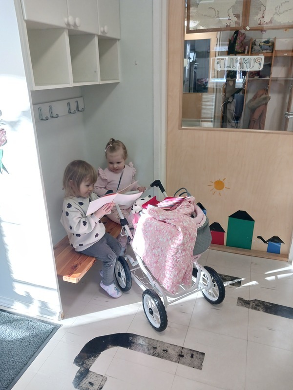Lapset leikkivät nukenvaunuilla.