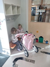 Lapset leikkivät nukenvaunuilla.