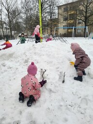 Lapset leikkivät isossa lumikasassa ja katselevat pieniä lumiukkoja.