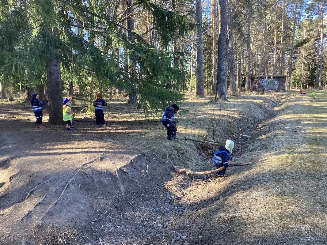 Lapset leikkivät metsässä.