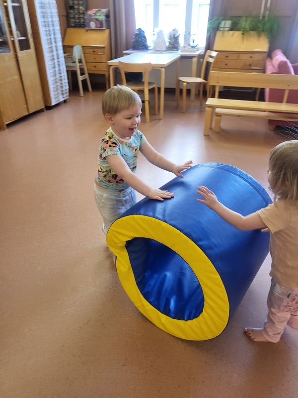 Lapset kierittävät jumppasalissa isoa pehmorullaa.