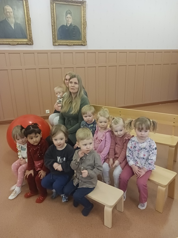 Lapset istuvat penkeillä ja odottavat teatterin alkua.