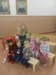 Lapset istuvat penkeillä ja odottavat teatterin alkua.