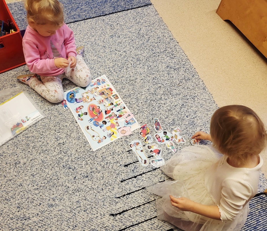 Lapset katselevat kuvia lattialla.