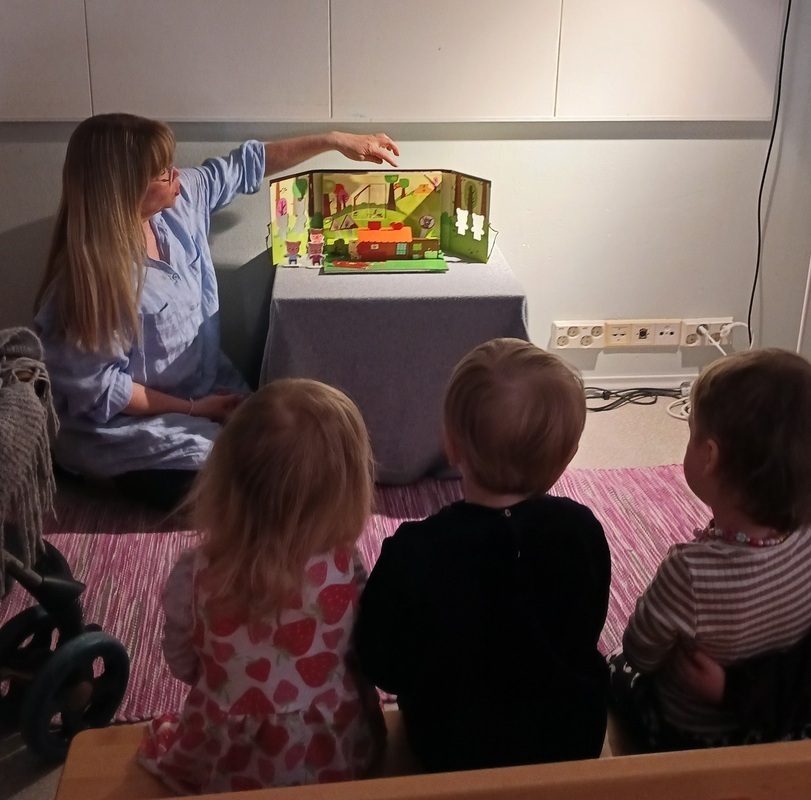 Lapset kuuntelevat pöytäteatterisatua.