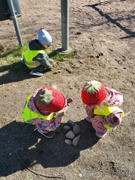 Lapset kasaavat kiviä yhteen kasaan.