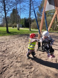 Lapsi antaa keinussa vauhtia toiselle lapselle.