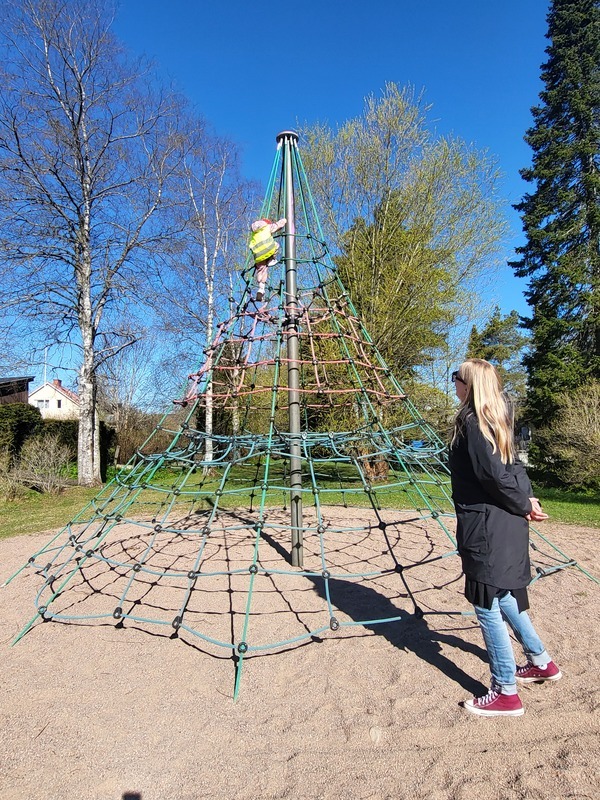 Lapsi kiipeilee korkealle kiipeilytelineessä.