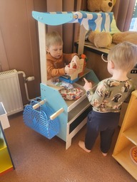 Kaksi lasta leikkii kauppaleikkiä.