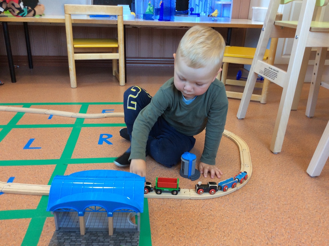 Poika leikkii junaradalla