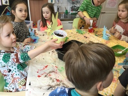 Lapset istuttavat ohran siemeniä pääsiäisruohopurkkeihin