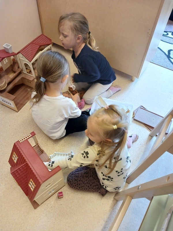 Kolme lasta leikkii yhdessä.