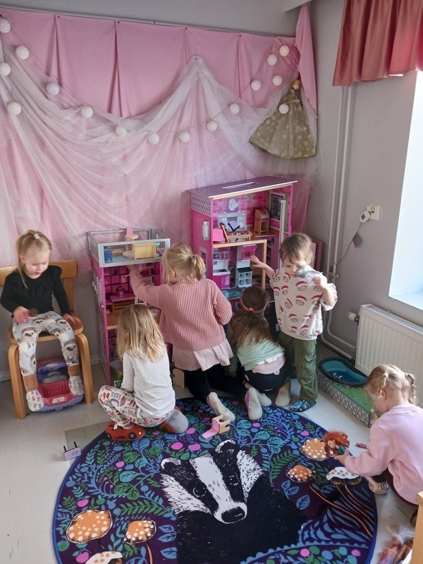 Lapset leikkivät barbitalolla.