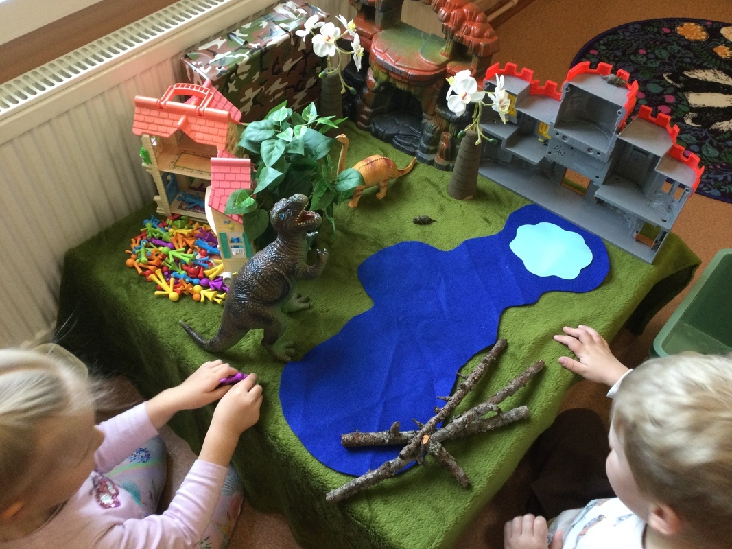 Lapset leikkivät dinoilla.