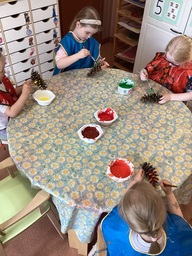 Lapset maalaavaat käpyjä syksyn väreillä.