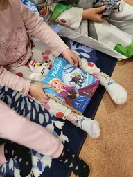 Lapset valmistautuvat kuuntelemaan kirjaa.