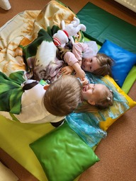 Lapset kikattelevat patjalla.