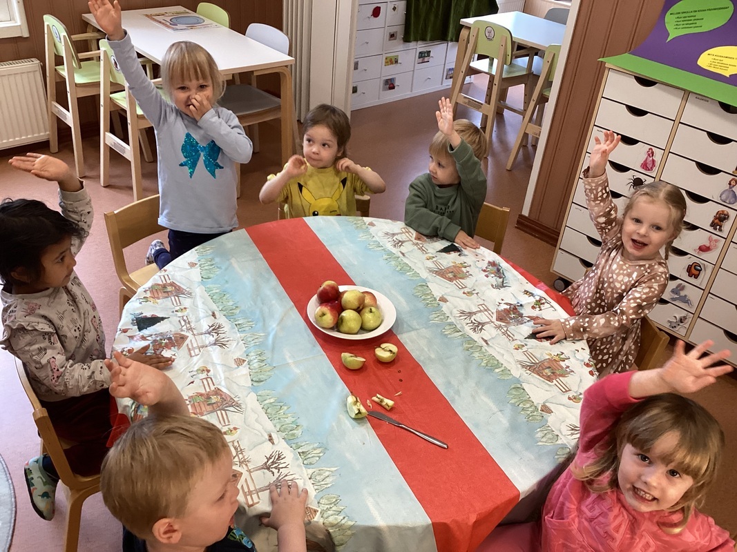 Lapset tutkivat omenoita ja vastaavat innokkaina viitaten, kun kysytään omenoihin liittyviä kysymyksiä.