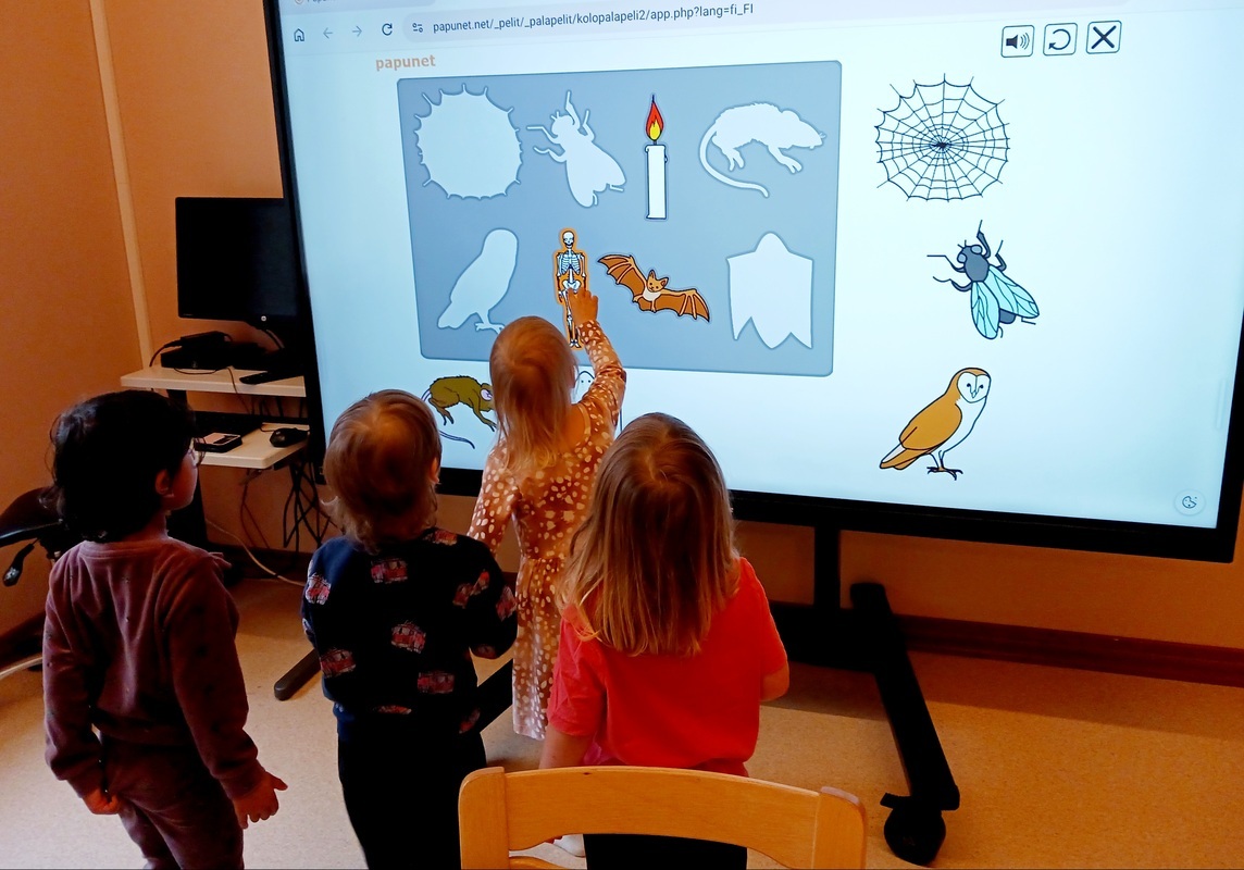 Lapsi tekee palapeliä smart taululla.