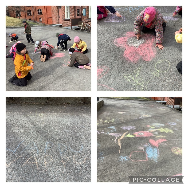 Lapset piirtävät katuliiduilla asfalttiin värikkäitä kuvia.