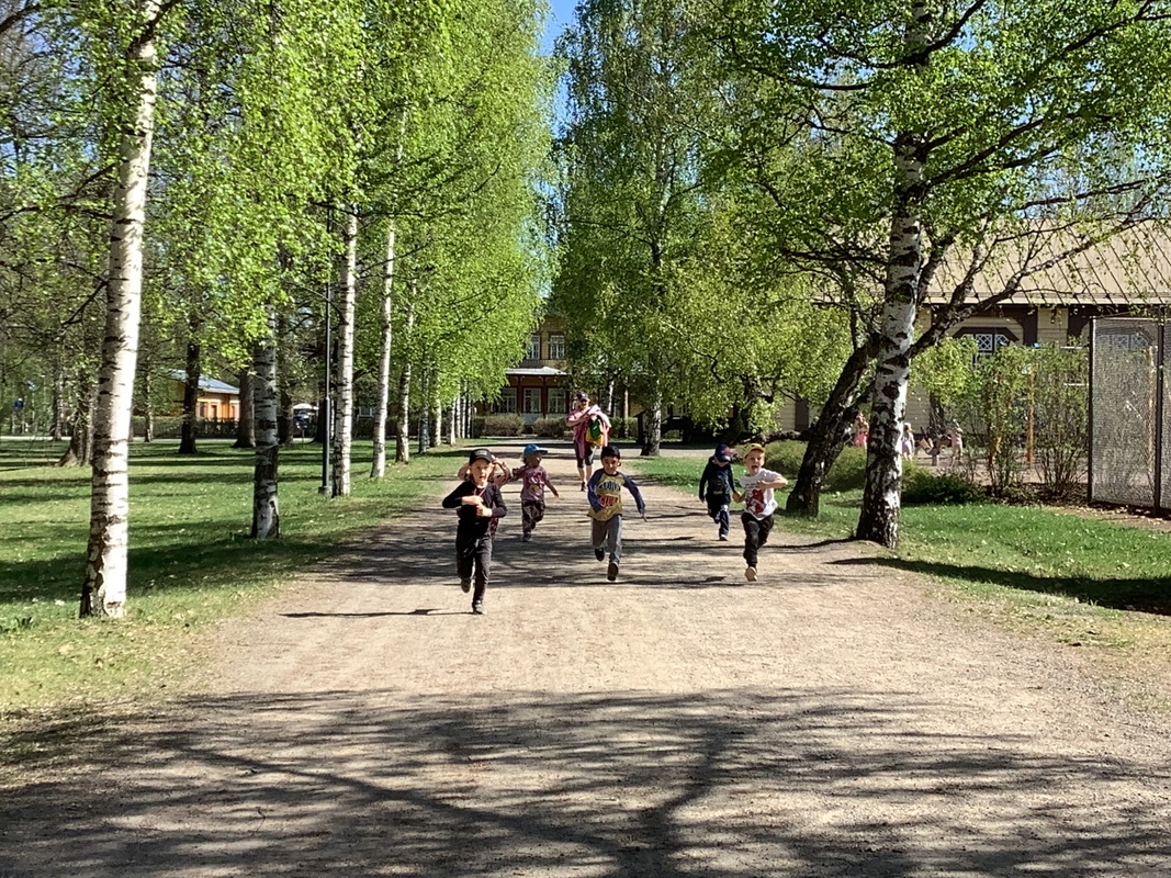 Lapset juoksevat puistossa.