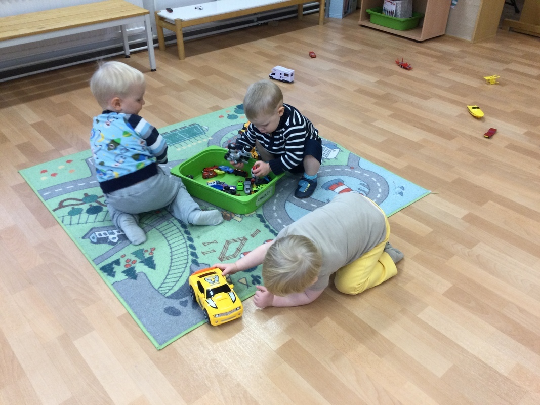 Lapset leikkivät autoilla.