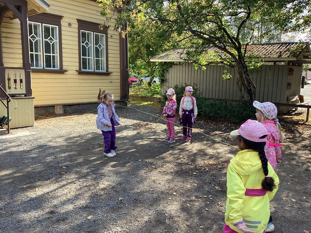 IMG_2463.jpeg Lapsia hyppimässä hyppynarua pihalla
