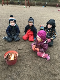 Lapset ihastelevat grillin tulta. Kohta paistetaan makkaraa.