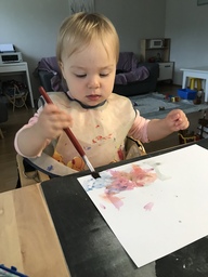 Lapsi maalaa vesiväreillä.