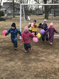 Lapset juoksevat ilmapallojen kanssa.