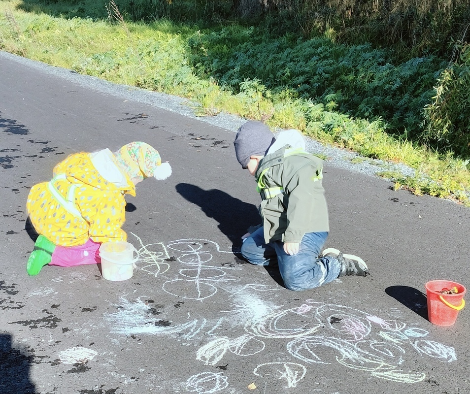 Lapset piirtämässä katuliiduilla
