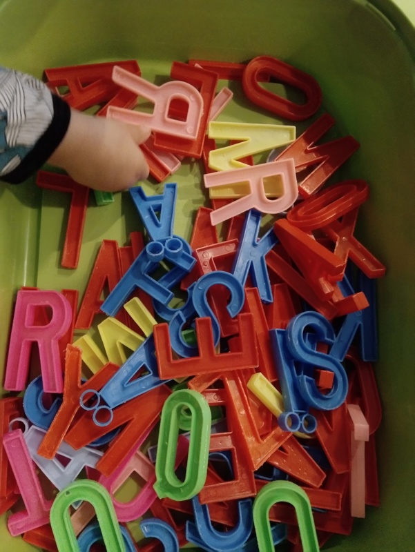 Erivärisiä muovikirjaimia muovilaatikossa