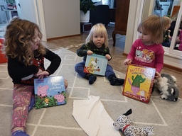 Lapset lattialla lukemassa kirjoja