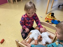 Lapsi hoitaa vauvanukkeja.