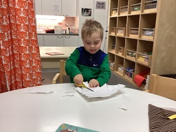 Lapsi leikkaa paperia saksilla.
