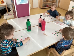 Lapset maalaavat puuhaarukoilla.